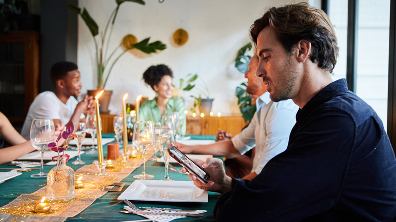 Man looking at phone in restaurant