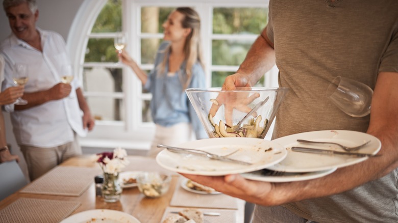 man helping clear plates