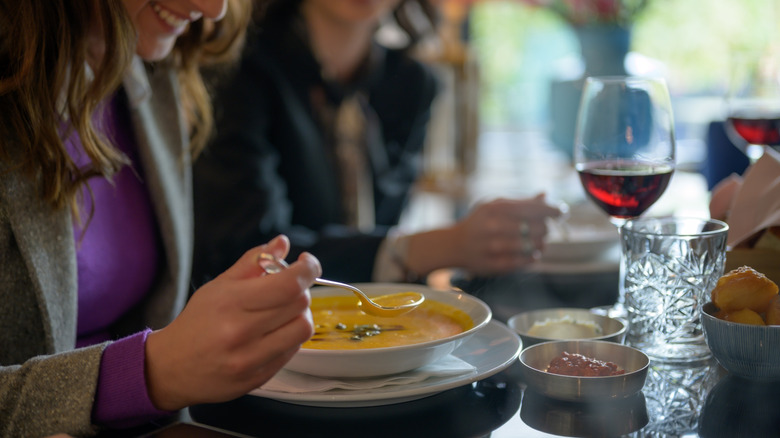 Woman eating soup in restaurant