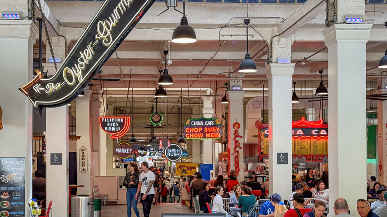 interior of los angeles central market with people sitting and eating below various restaurant signs