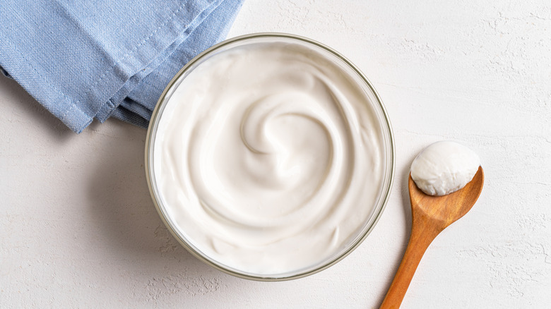 Greek yogurt sits in a glass bowl.