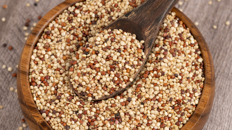 A spoon sits in a bowl of quinoa.