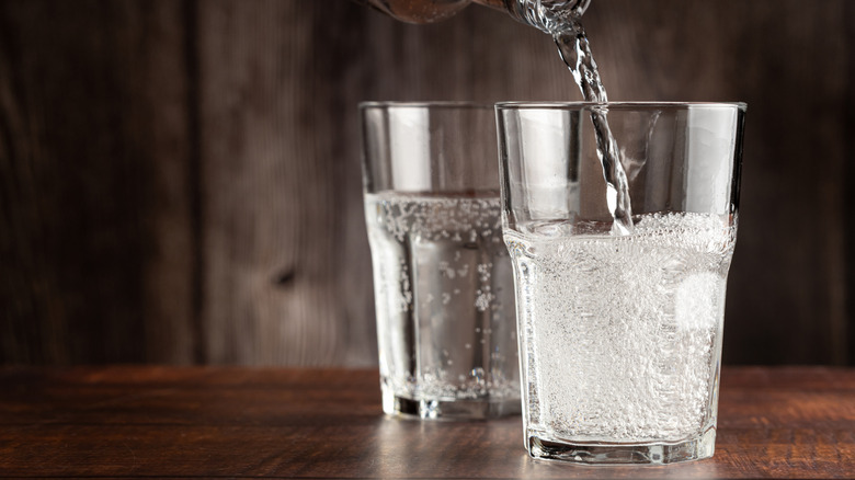 two glasses of seltzer on a wooden table