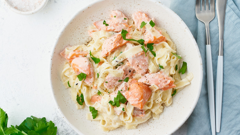 A creamy pasta dish with salmon, freshly cracked black pepper, and fresh parsley.