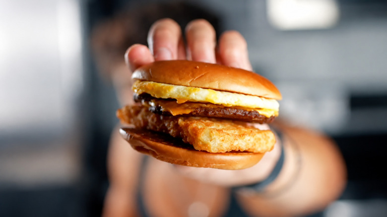A hand holds a McBrunch Burger.