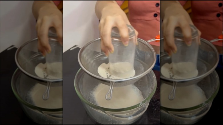 Sifting flour with glass and sieve