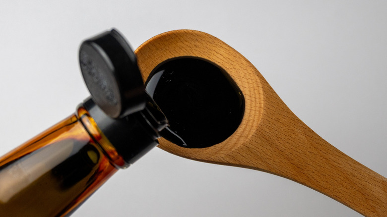 Soy sauce poured onto a wooden spoon