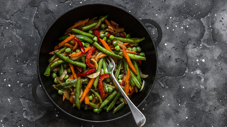 Bowl filled with green beans and other vegetables.