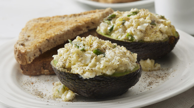 Egg salad in halved avocado with toast
