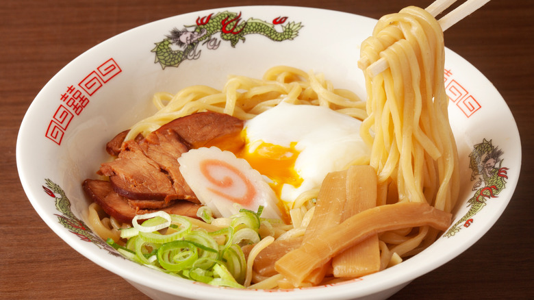 ramen noodles with toppings in decorated bowl with chopsticks