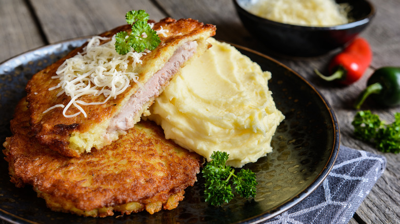Pork schnitzel coated in potato with mashed potatoes