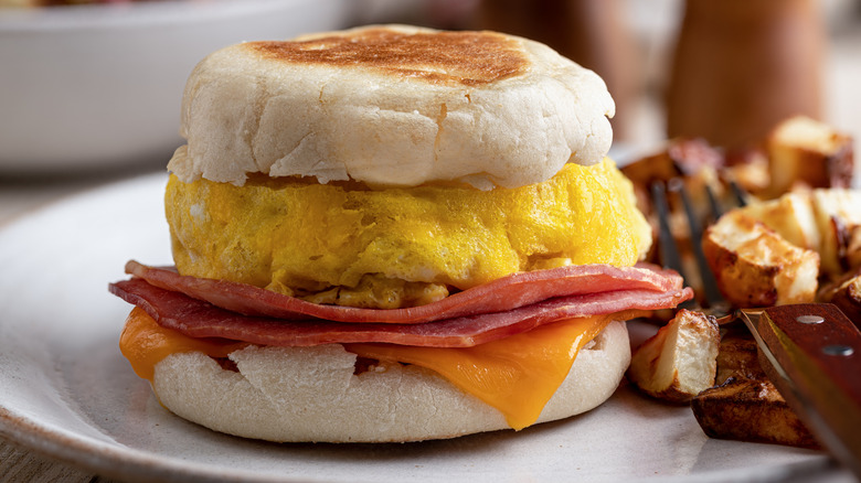 Breakfast sandwich with egg, ham and cheese on an English muffin