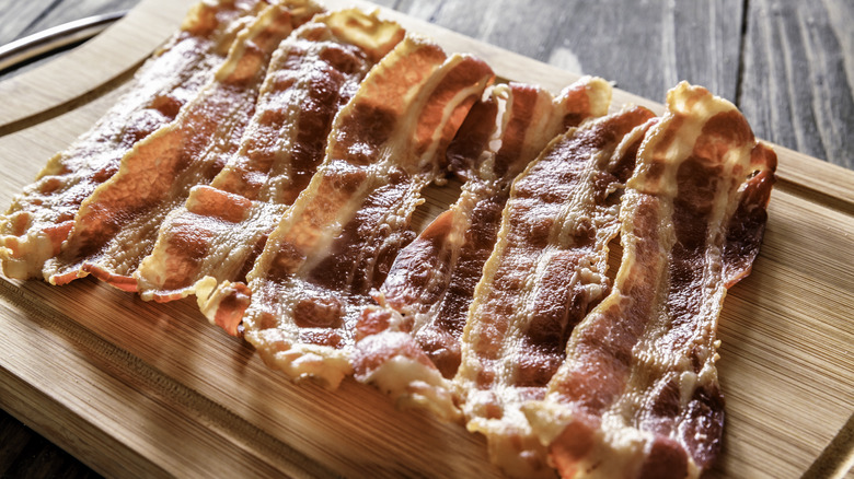 Slices of crisp bacon on cutting board