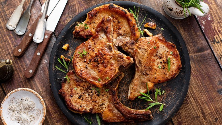 Cooked pork chops on black plate
