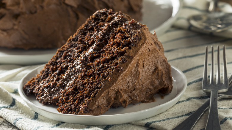 slice of chocolate cake with chocolate frosting on plate