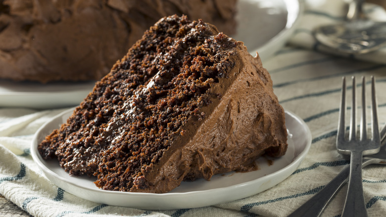 slice of chocolate cake with chocolate frosting on plate