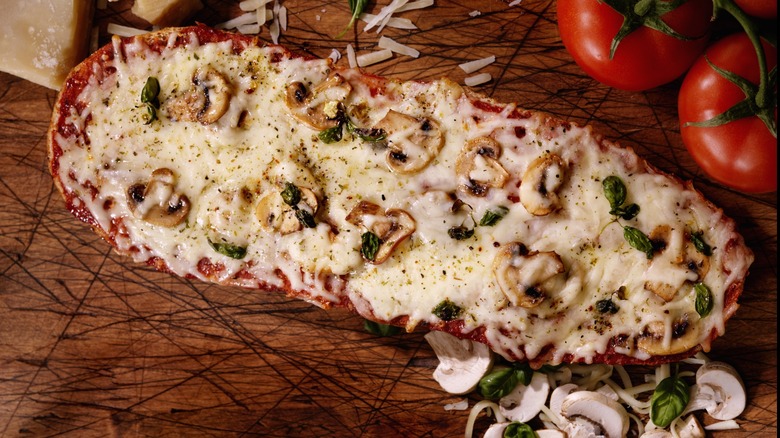 A French bread pizza topped with mushrooms and fresh basil
