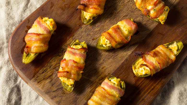 Bacon-wrapped jalapeño poppers on wooden board