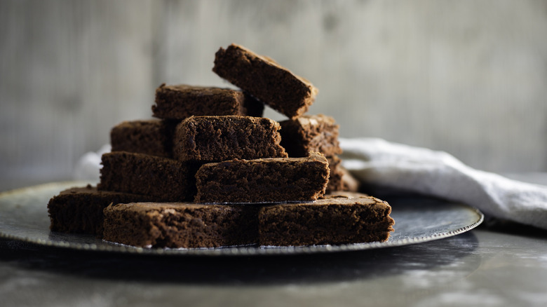A pile of brownies stacked on top of each other on a plate