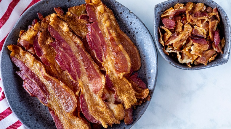 Crispy flat bacon and crumbles on gray dishes