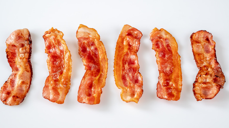 Fried bacon rashers on a white background