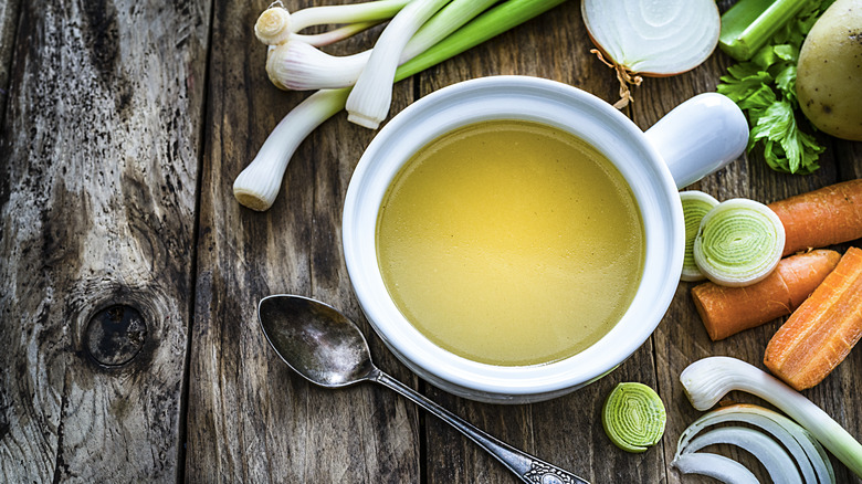 Vegetable broth in a bowl with cut vegetables