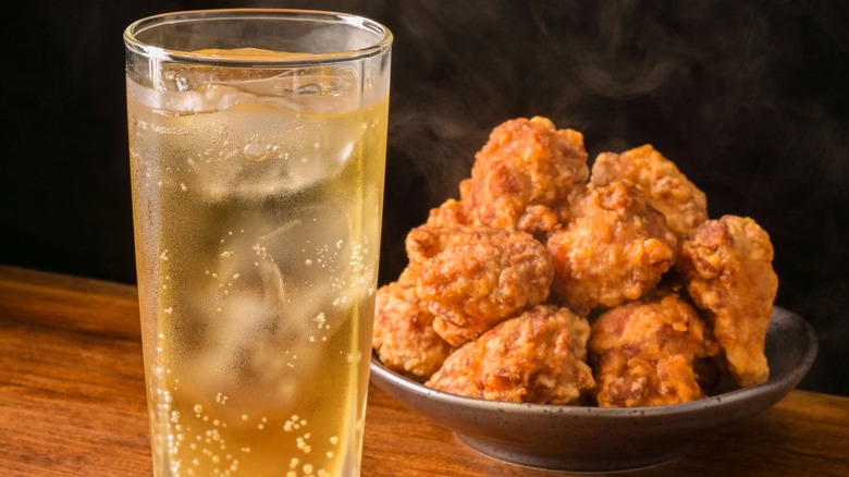 Fried chicken next to a glass of whiskey soda