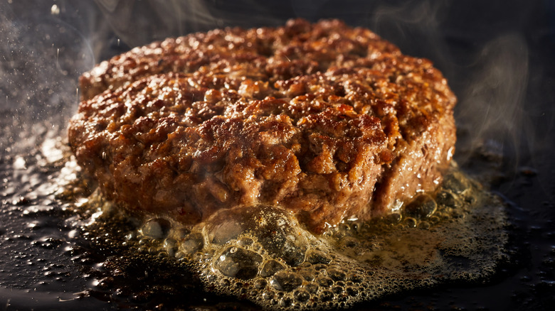 hamburger cooking on a plancha