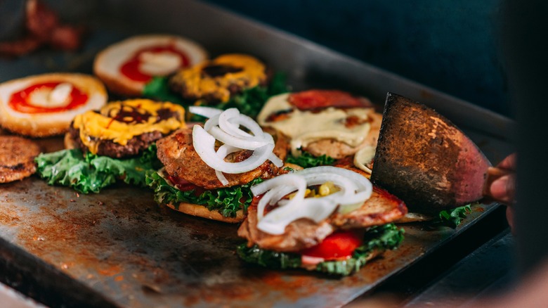 hamburgers being assembled on a plancha
