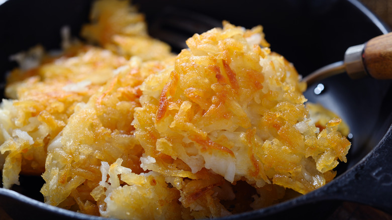 Hash browns cooking in a cast iron pan