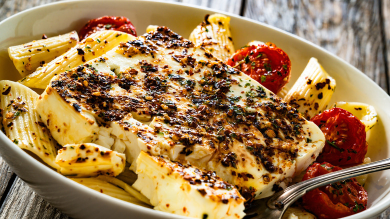 penne pasta with roasted tomatoes and herb seasoned feta in a large bowl.