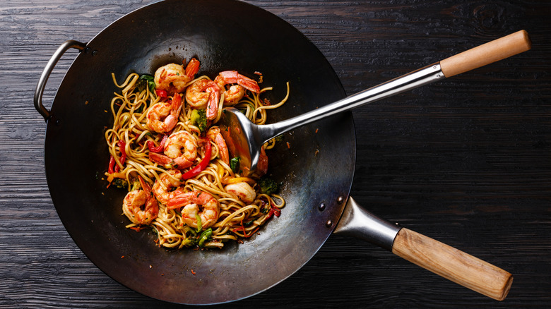 a wok with stir-fried noodles and shrimp