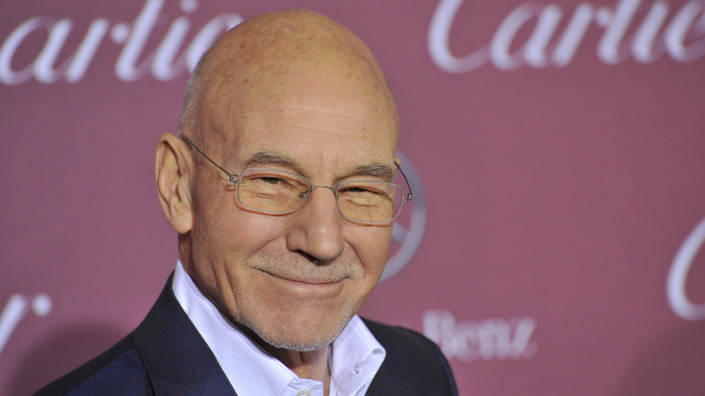 Sir Patrick Stewart smiles on a red carpet.
