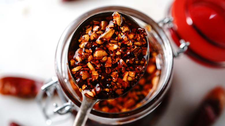 A spoonful of chili crisp over a jar