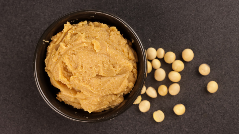 A bowl of miso paste surrounded by soy beans