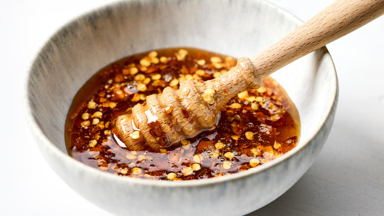 A honey dipper in a bowl of hot honey