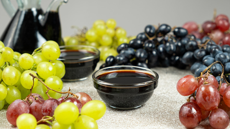 Balsamic vinegar in a bowl surrounded by grapes