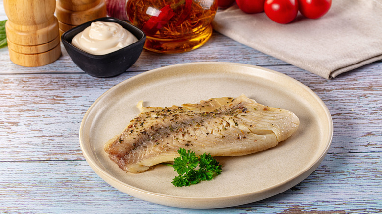 Seasoned tilapia fillet on a plate.