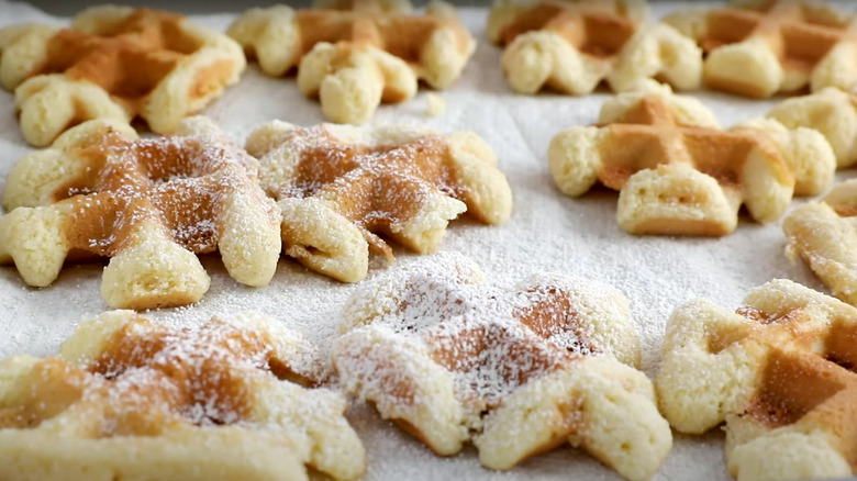 waffle iron cookies in pan with powdered sugar