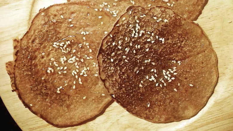 Flat, Greek pancakes drizzled with honey and sesame seeds
