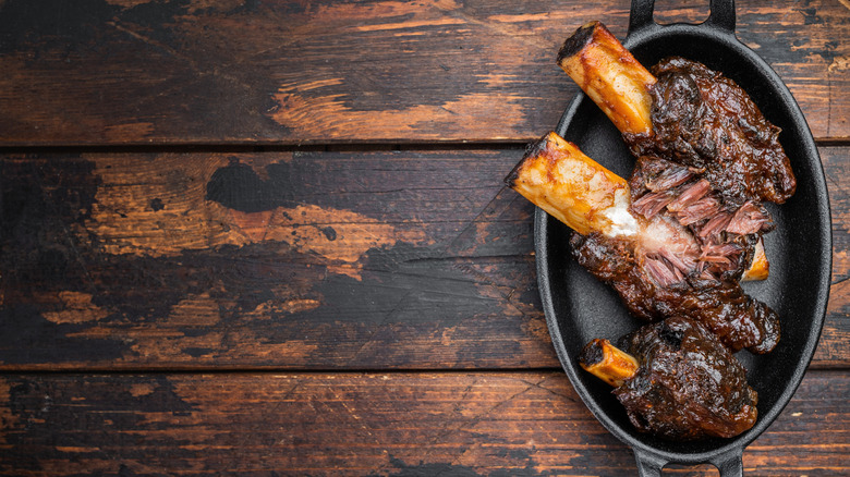 A cast iron plate with three large short ribs rests on a wooden table
