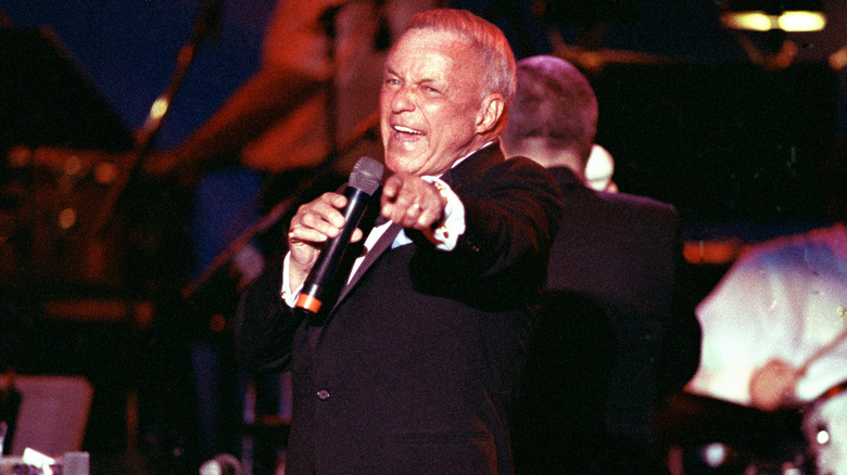 Frank Sinatra singing on stage with a microphone