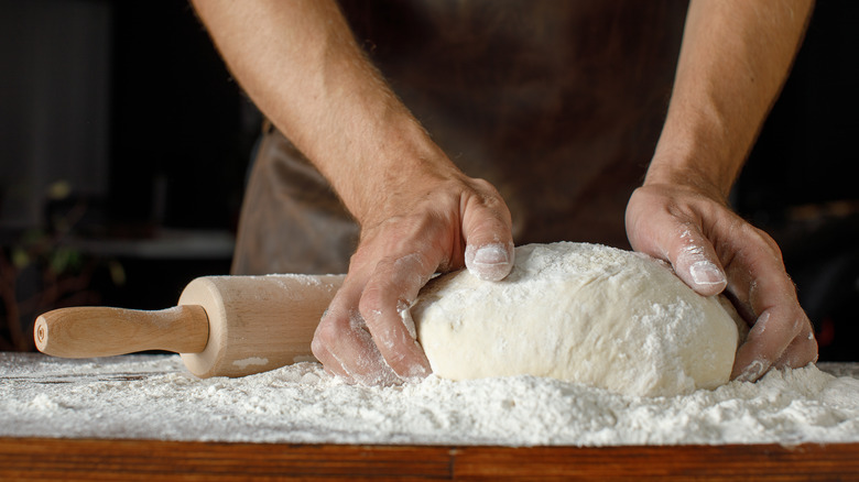 person kneading dough