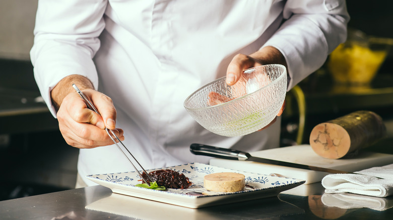 Chef adding leaves to plate