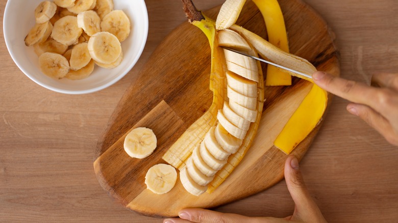 Woman cutting up a banana