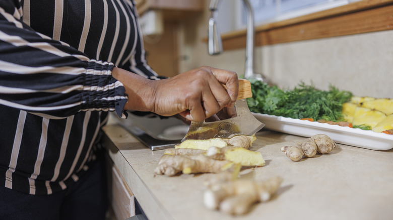 A woman chops fresh ginger