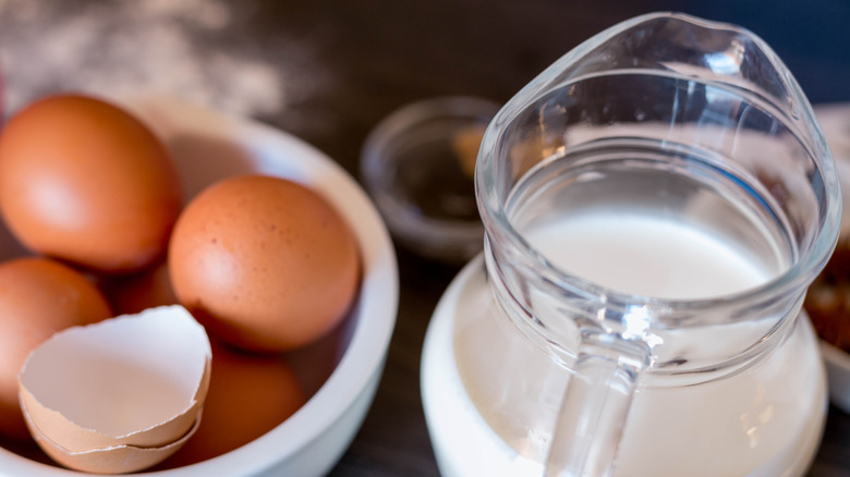 Some eggs in a bowl and milk in a jugg