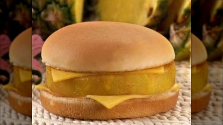 Re-creation of McDonald's Hula Burger on a woven surface in front of pineapple