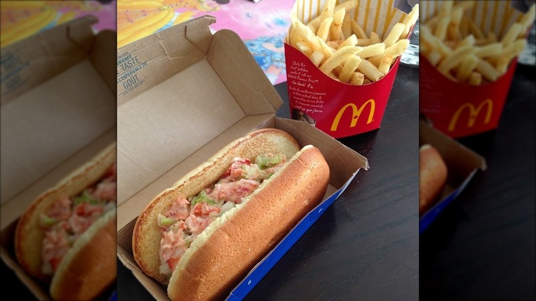 McLobster and McDonald's french fries on a dark wooden table