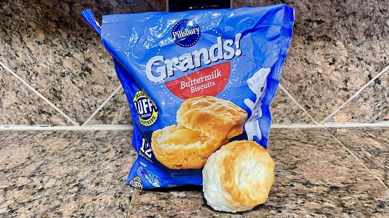 Bag of frozen Pillsbury Grands! Buttermilk Biscuits with a cooked one in front